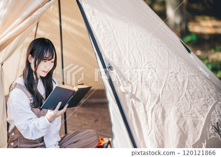 年輕女子在帳篷裡享受讀書 年輕女子在帳篷裡享受讀書 120121866