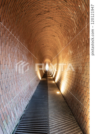 The Deer Moat Pedestrian Tunnel near Prague Castle features a unique brick design, inviting visitors to stroll through its illuminated pathway on their journey. 120121947