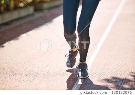 一位穿著運動服慢跑的年輕女子的腳 一位穿著運動服慢跑的年輕女子的腳 120122076