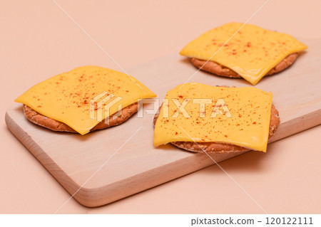 Cracker Sandwiches with Cheese and Paprika on Cutting Board 120122111