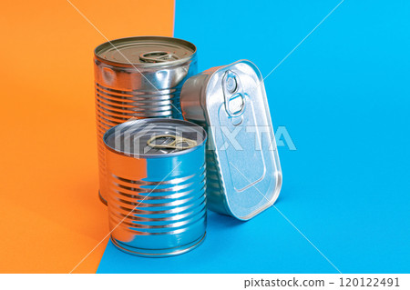 A Group of Stacked Tin Cans with Blank Edges on Split Blue and Orange Background A Group of Stacked Tin Cans with Blank Edges on Split Blue and Orange Background 120122491