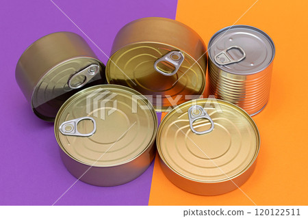 A Group of Stacked Tin Cans with Blank Edges on Split Orange and Violet Background 120122511