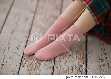The feet of a young woman putting on socks The feet of a young woman putting on socks 120122853