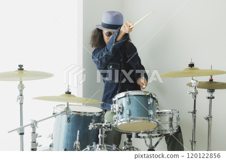 A man with long hair playing the drums A man with long hair playing the drums 120122856