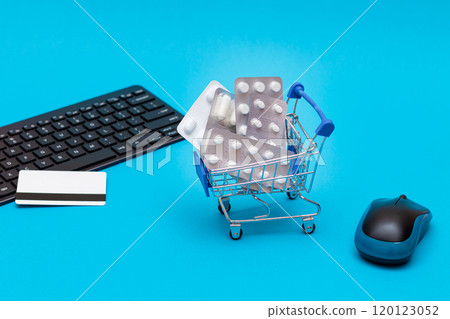 Ordering Medicines. Pills and Capsules in a Shopping Cart on Blue Background Ordering Medicines. Pills and Capsules in a Shopping Cart on Blue Background 120123052