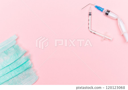 Broken Medical Syringe and Torn Medical Face Mask on the Pink Background 120123068