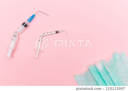 Broken Medical Syringe and Torn Medical Face Mask on the Pink Background Broken Medical Syringe and Torn Medical Face Mask on the Pink Background 120123097