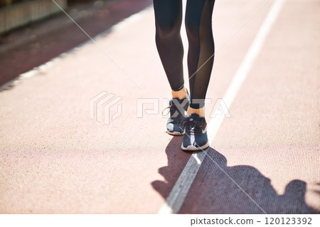 一位穿著運動服慢跑的年輕女子的腳 一位穿著運動服慢跑的年輕女子的腳 120123392