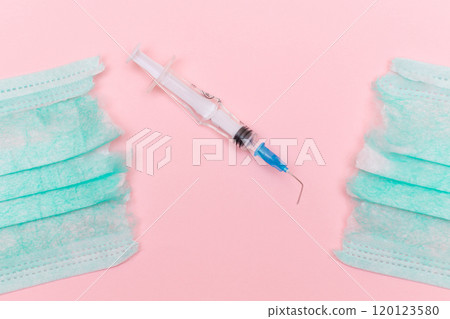 Broken Medical Syringe and Torn Medical Face Mask on the Pink Background Broken Medical Syringe and Torn Medical Face Mask on the Pink Background 120123580