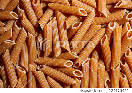 Uncooked Whole Grain Penne Rigate Pasta Background Uncooked Whole Grain Penne Rigate Pasta Background 120123691