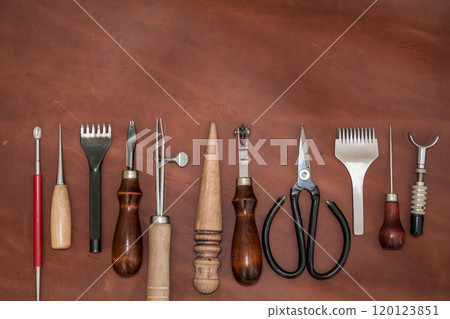 Pieces of natural calf leather and tools for leather processing. A leather craftsman's workshop. 120123851