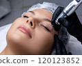 A beautician does permanent eyeliner makeup on a woman. Tattooing in a beauty salon. 120123852
