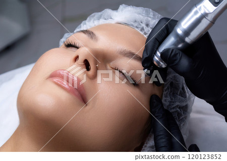 A beautician does permanent eyeliner makeup on a woman. Tattooing in a beauty salon. A beautician does permanent eyeliner makeup on a woman. Tattooing in a beauty salon. 120123852