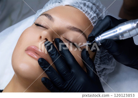 A beautician does permanent eyeliner makeup on a woman. Tattooing in a beauty salon. A beautician does permanent eyeliner makeup on a woman. Tattooing in a beauty salon. 120123853