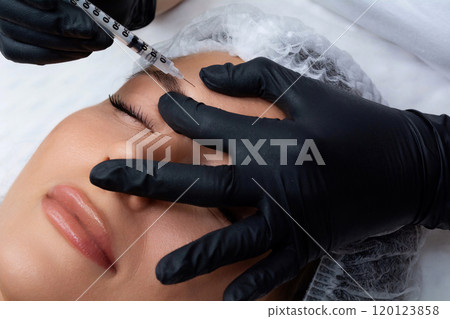 A beautician gives a woman a Botox injection. A procedure for beauty and rejuvenation. A beautician gives a woman a Botox injection. A procedure for beauty and rejuvenation. 120123858