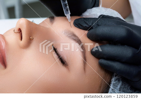 A beautician gives a woman a Botox injection. A procedure for beauty and rejuvenation. A beautician gives a woman a Botox injection. A procedure for beauty and rejuvenation. 120123859