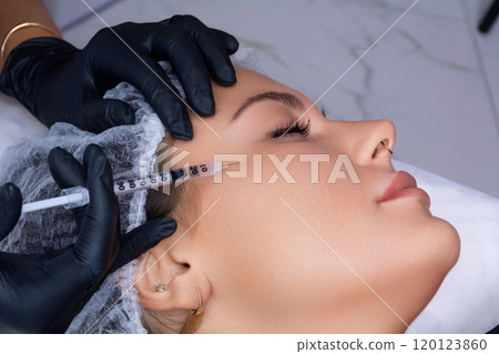 A beautician gives a woman a Botox injection. A procedure for beauty and rejuvenation. 120123860