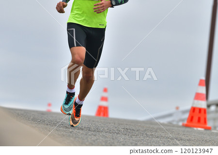 Marathon: The feet of a marathon runner running up a hill Marathon: The feet of a marathon runner running up a hill 120123947