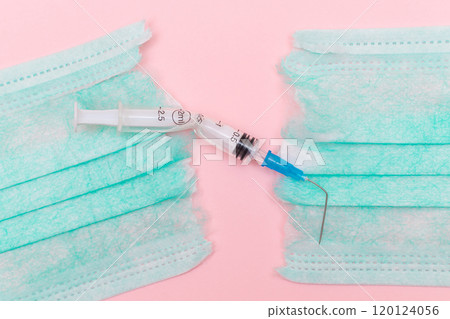 Broken Medical Syringe and Torn Medical Face Mask on the Pink Background 120124056
