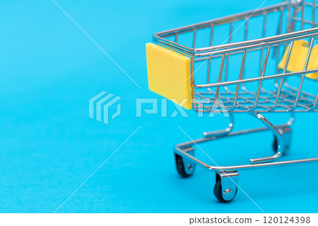 Empty Yellow Shopping Cart on Blue Background Empty Yellow Shopping Cart on Blue Background 120124398
