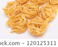 Scattered Classic Italian Raw Egg Fettuccine on White Table 120125311