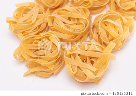 Scattered Classic Italian Raw Egg Fettuccine on White Table 120125311