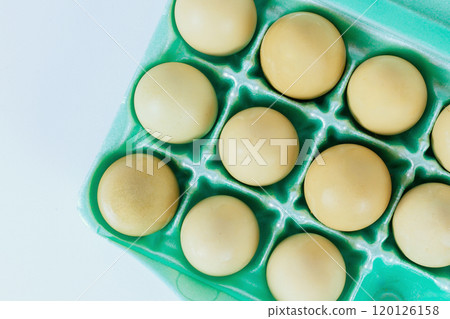 One dozen yellow eggs nestled neatly in an egg carton ready to be used for cooking baking One dozen yellow eggs nestled neatly in an egg carton ready to be used for cooking baking 120126158