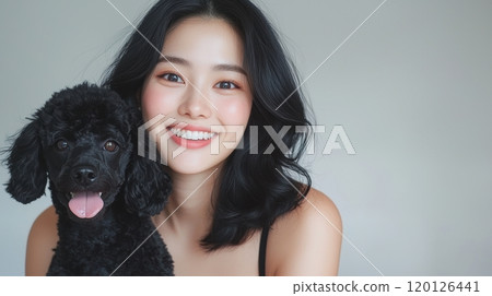 Smiling woman with black poodle dog on a neutral background 120126441