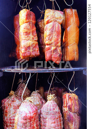 It is culinary tradition comprised of various cuts meat smoked a smoker bacon hung on hooks that creates delicious treat in smokehouse It is culinary tradition comprised of various cuts meat smoked a smoker bacon hung on hooks that creates delicious treat in smokehouse 120127554