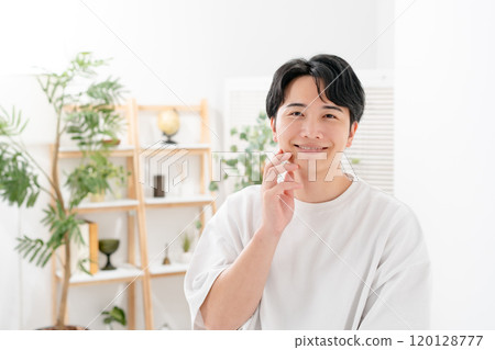 Man touching his cheek, smiling 120128777