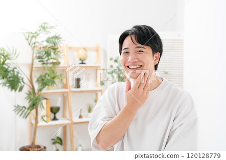Man touching his cheek, smiling 120128779