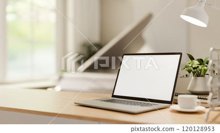 A close-up of a laptop and decor on a minimal wooden table in a bright room. A close-up of a laptop and decor on a minimal wooden table in a bright room. 120128953