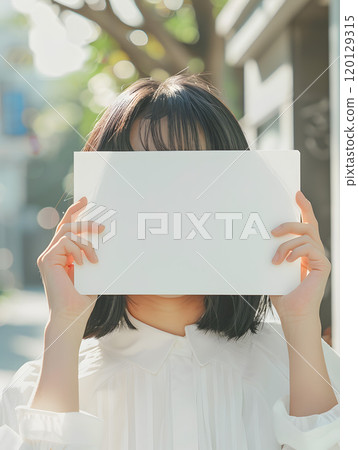 Asian woman holding a whiteboard under the summer sun 120129315
