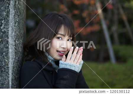 A young woman warming her hands with her breath in Sakuranomiya Park in Miyakojima-ku, Osaka City, Osaka Prefecture 120130112