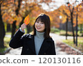 大阪府大阪市宮古島區櫻之宮公園,在秋葉背景下,微笑的年輕女子右手握著一片葉子 大阪府大阪市宮古島區櫻之宮公園,在秋葉背景下,微笑的年輕女子右手握著一片葉子 120130116