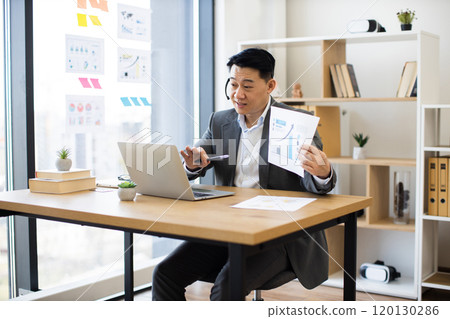 Asian businessman in headset presenting during virtual meeting Asian businessman in headset presenting during virtual meeting 120130286