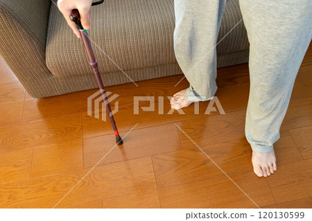 A person standing with a cane in a room 120130599