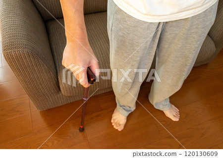 A man standing with a cane in a room 120130609
