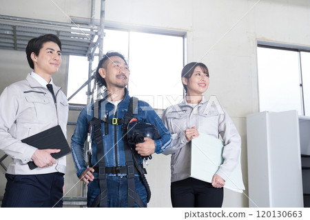 穿著工作服的總承包商和穿著牛仔布的現場主管等三人,抬頭看著現場的 IT 和 DX。 穿著工作服的總承包商和穿著牛仔布的現場主管等三人,抬頭看著現場的 IT 和 DX。 120130663