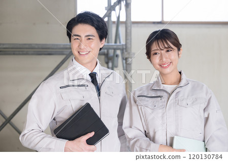 兩名年輕男女工人在建築工地工作 120130784