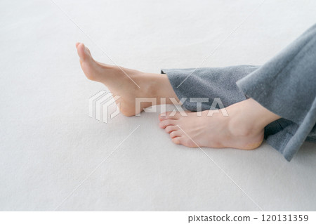 The feet of a woman lying on the floor 120131359