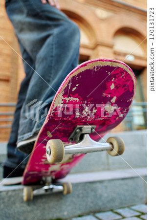 Close-up of skateboarder on pink skateboard at street 120131723