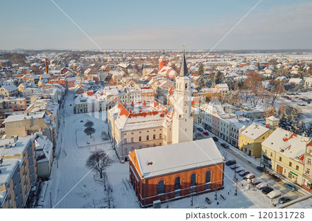 Snowy town center with church tower rising above buildings in winter 120131728