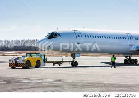 The tractor is towing the passenger airplane 120131756
