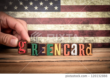GREEN CARD. Colorful letters of the alphabet on a wooden texture table 120132866