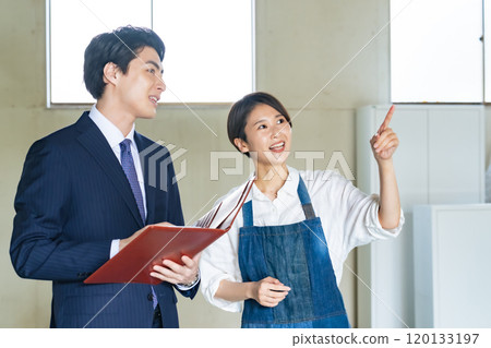 A store manager and a salesman looking at a used property A store manager and a salesman looking at a used property 120133197