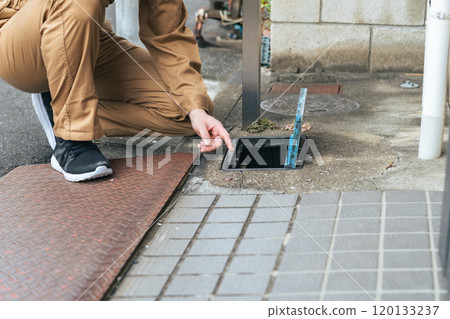 Worker checking the water meter 120133237