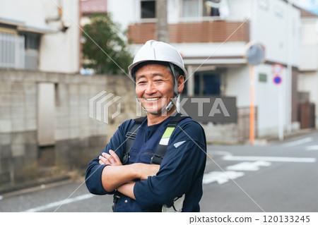 Senior worker standing in a residential area 120133245