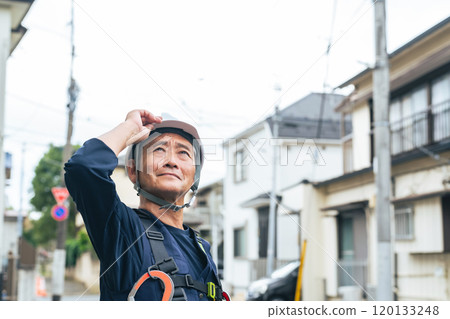 Senior worker standing in a residential area 120133248