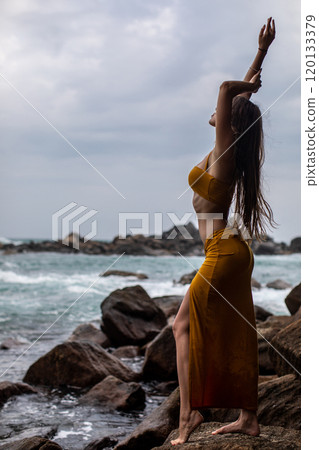 An Elegant Model Gracefully Posing Amid Nature by the Beautiful and Peaceful Shoreline An Elegant Model Gracefully Posing Amid Nature by the Beautiful and Peaceful Shoreline 120133379